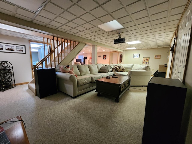 living room with a paneled ceiling and carpet