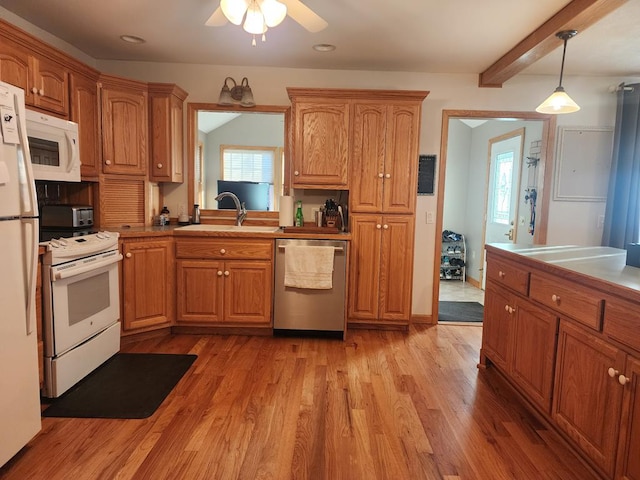 kitchen with pendant lighting, white appliances, light hardwood / wood-style floors, and beamed ceiling