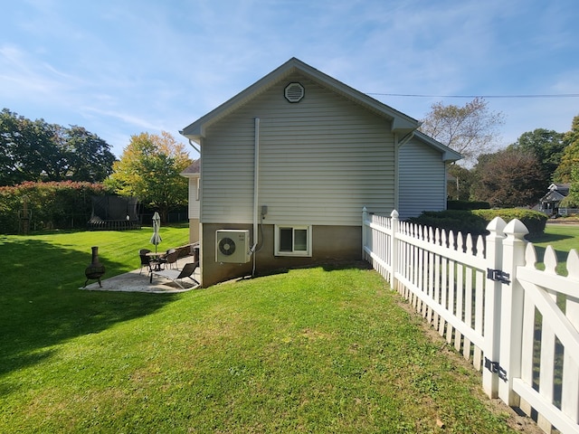 view of side of home with a yard and a patio