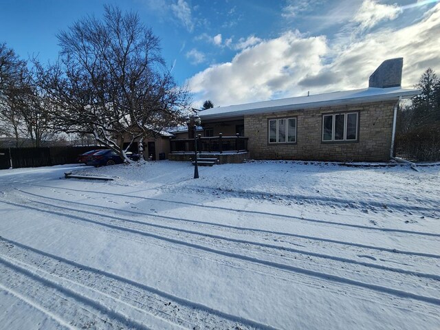 view of snow covered back of property