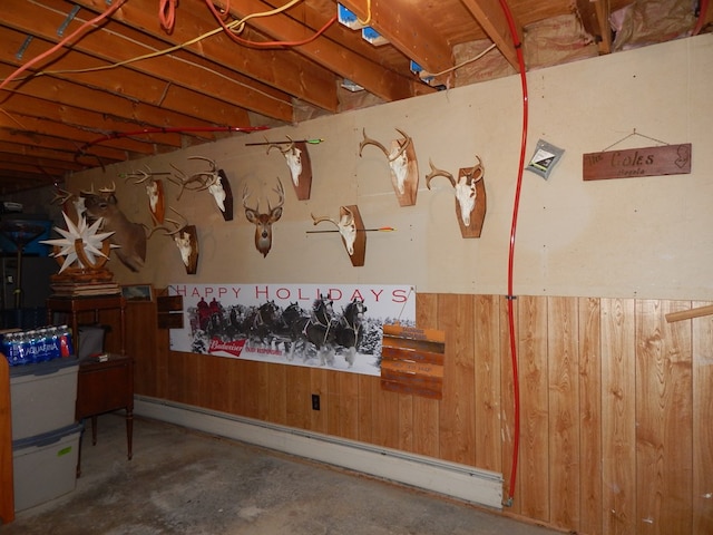 miscellaneous room with baseboard heating, concrete floors, and wooden walls