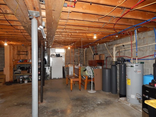 unfinished basement featuring washer / clothes dryer, water heater, and freestanding refrigerator