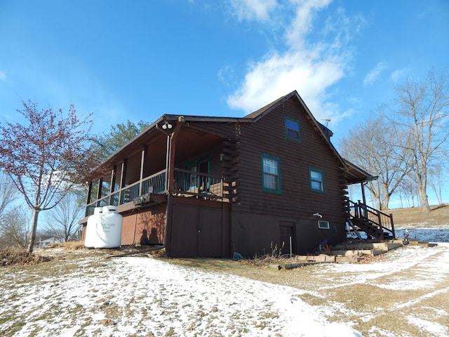 view of snow covered exterior with log exterior