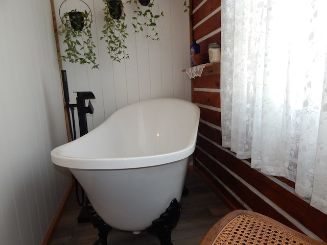 bathroom with a freestanding bath and wood finished floors