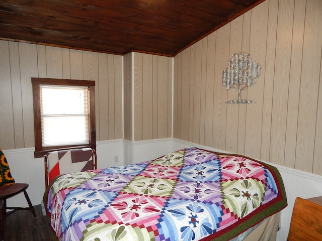 bedroom with a wainscoted wall and wooden ceiling