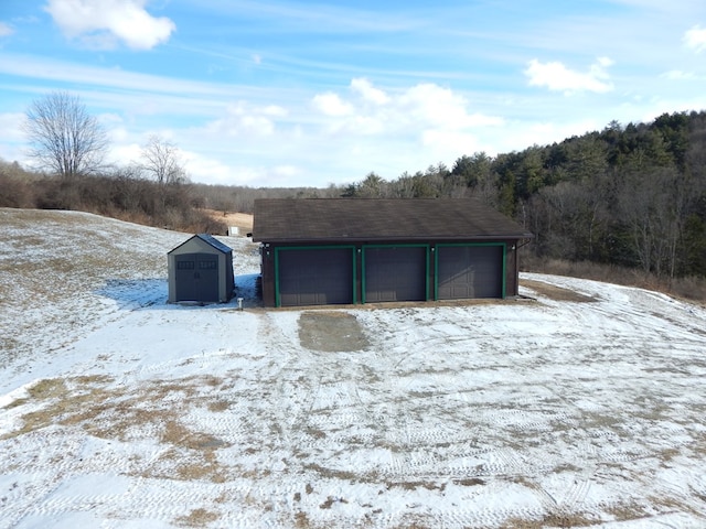 snow covered garage with a detached garage