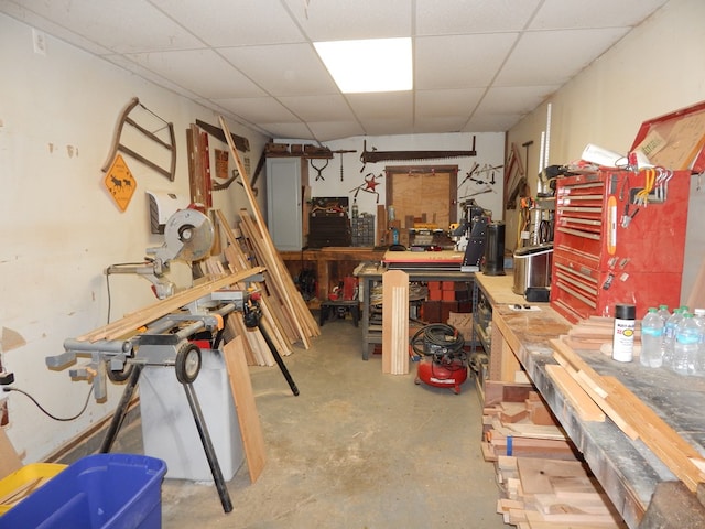 basement with a workshop area and a paneled ceiling