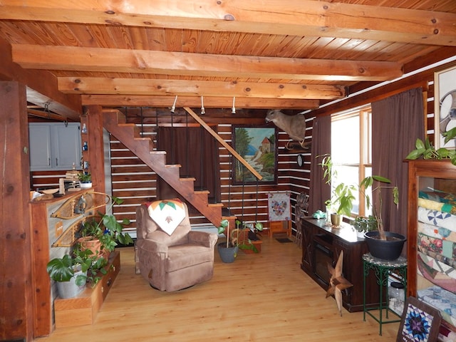 living area featuring beamed ceiling, wood ceiling, stairs, and wood finished floors