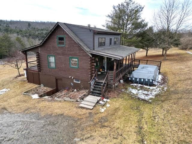 rear view of house featuring log exterior