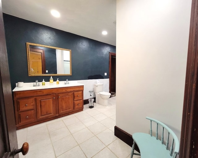 full bath featuring double vanity, tile patterned flooring, a sink, and toilet
