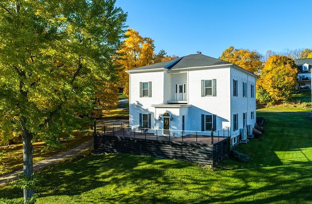 rear view of property featuring a lawn