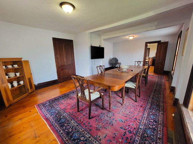 dining room with light wood-style floors, visible vents, and baseboards