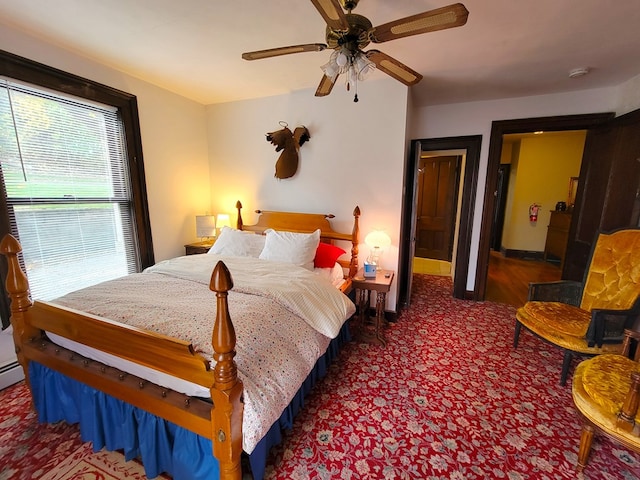 carpeted bedroom with ceiling fan and baseboards