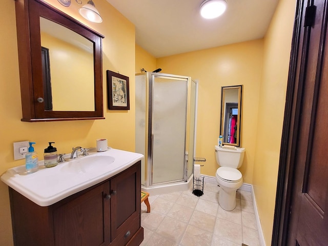 bathroom featuring toilet, a stall shower, baseboards, and vanity