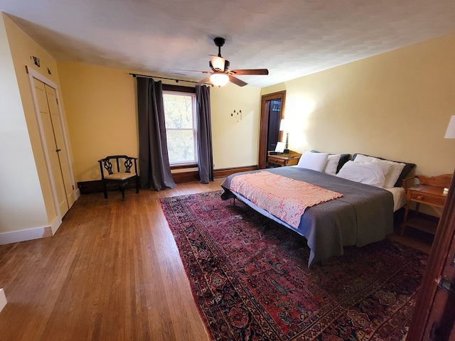 bedroom with ceiling fan, baseboards, and wood finished floors