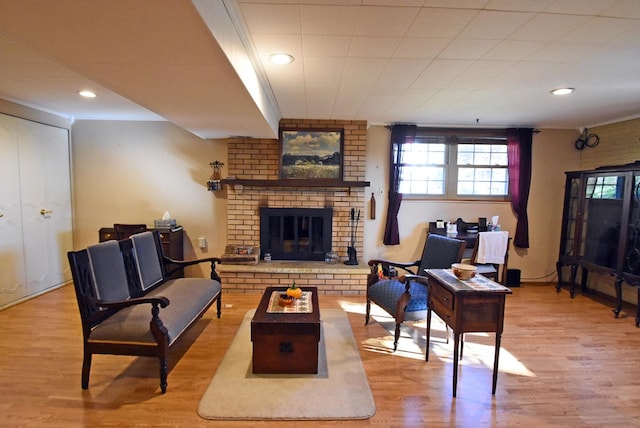 living room with a brick fireplace and light wood-type flooring