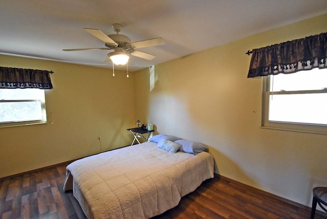 bedroom with dark hardwood / wood-style floors and ceiling fan