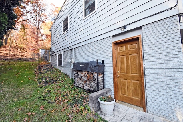 view of exterior entry with a lawn