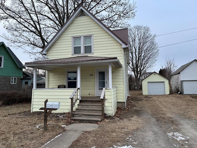 bungalow-style home with an outbuilding, a garage, and a porch