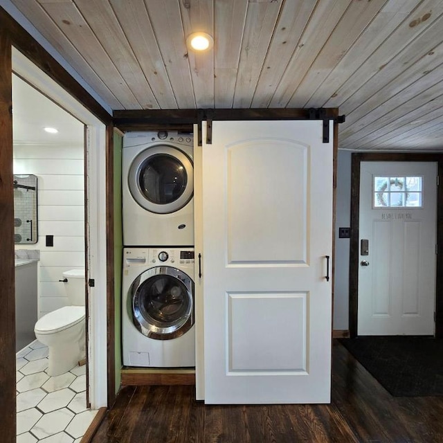 clothes washing area featuring hardwood / wood-style flooring, wooden ceiling, and stacked washing maching and dryer