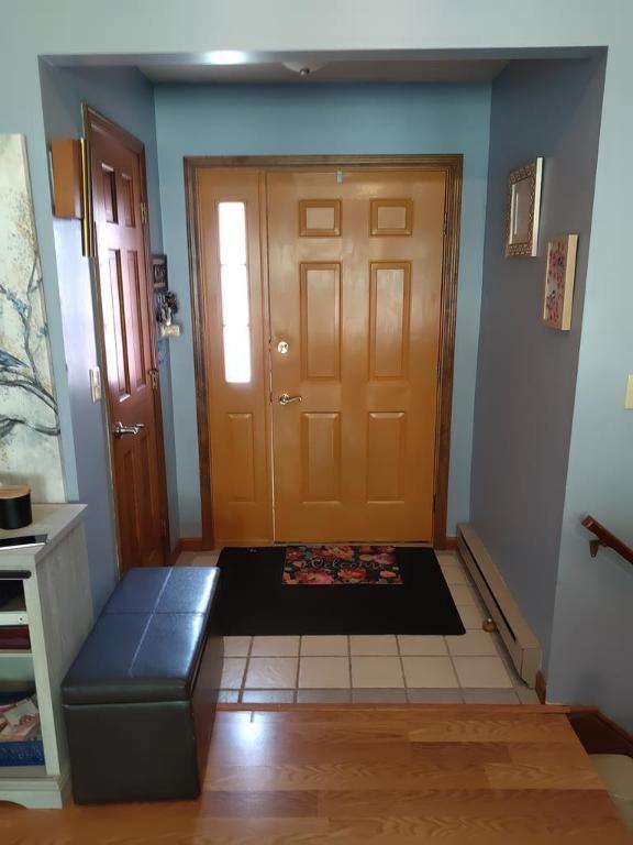 entrance foyer with a baseboard heating unit and light wood-type flooring