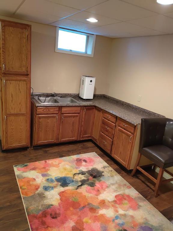 kitchen with dark wood-type flooring, a paneled ceiling, and sink