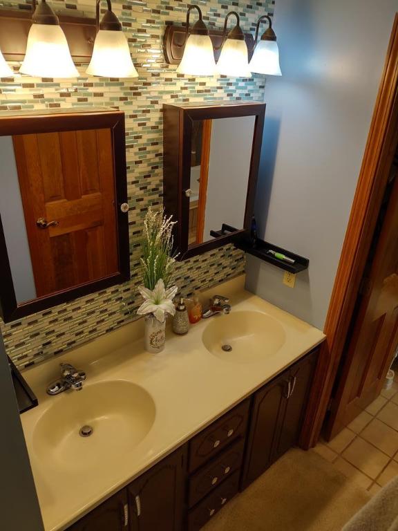 bathroom with tile patterned floors, decorative backsplash, and vanity