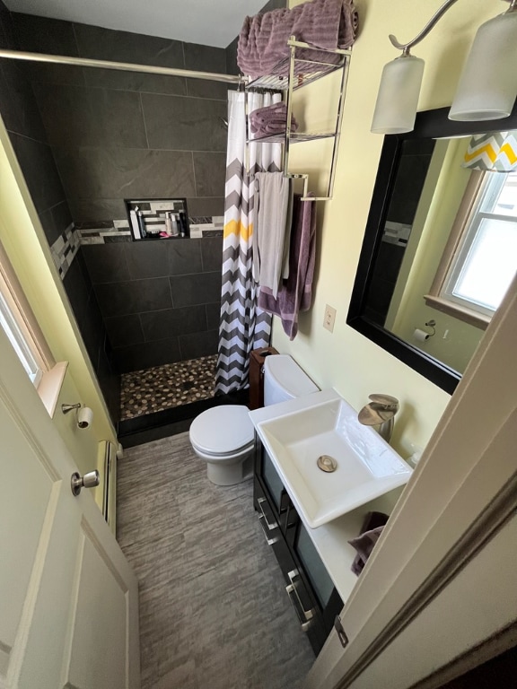 bathroom featuring vanity, toilet, curtained shower, and hardwood / wood-style floors