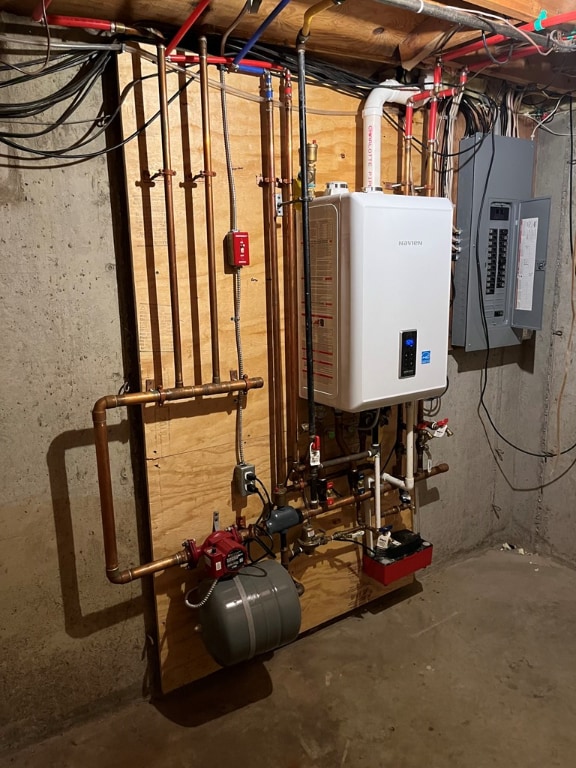 utility room with electric panel and tankless water heater