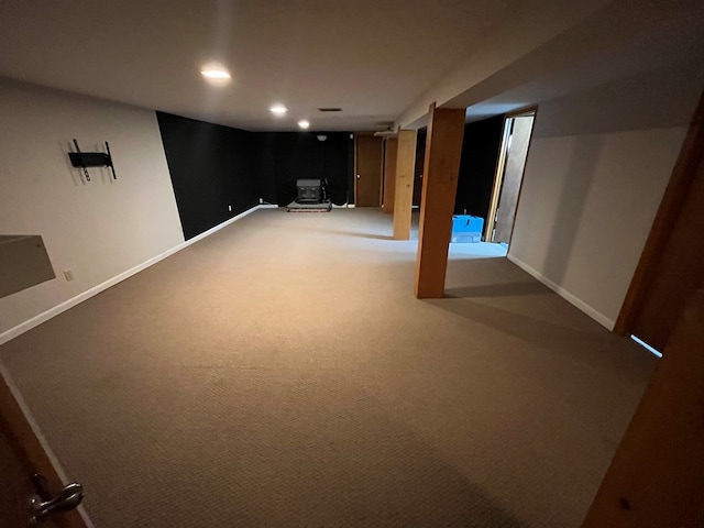 basement with carpet floors and a wood stove