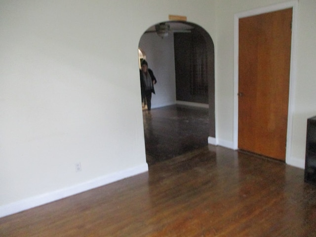 unfurnished room with dark wood-type flooring