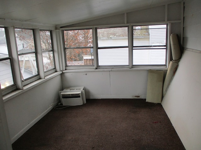 unfurnished sunroom featuring vaulted ceiling and a wall unit AC