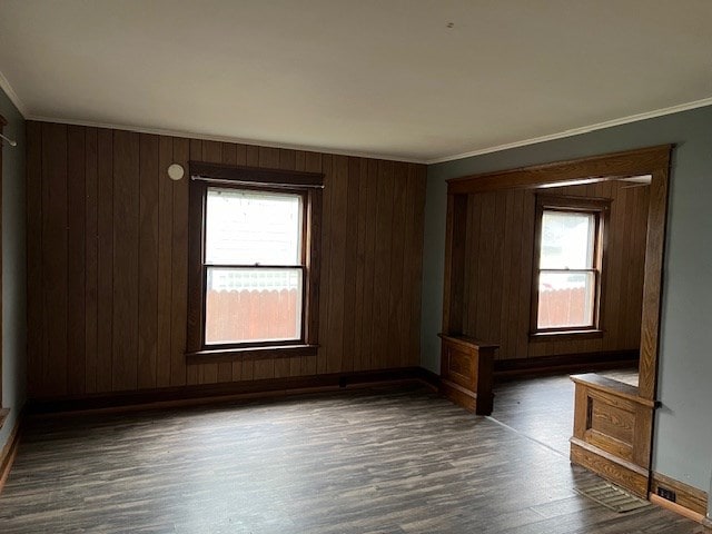 unfurnished bedroom with crown molding and dark wood-type flooring