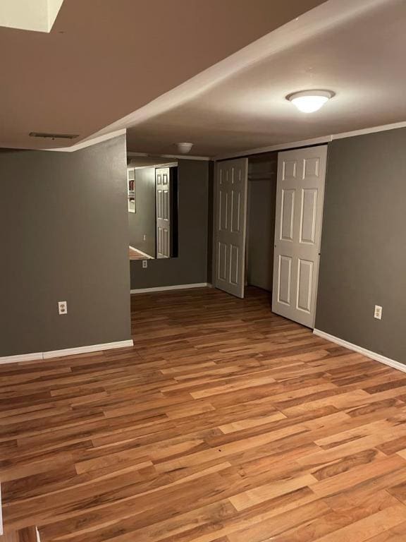 unfurnished room with wood-type flooring and crown molding