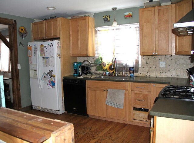 kitchen with sink, dishwasher, tasteful backsplash, white refrigerator with ice dispenser, and exhaust hood