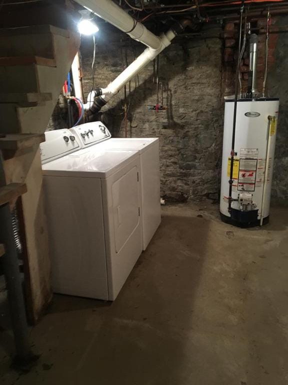 laundry room with water heater and washer and dryer