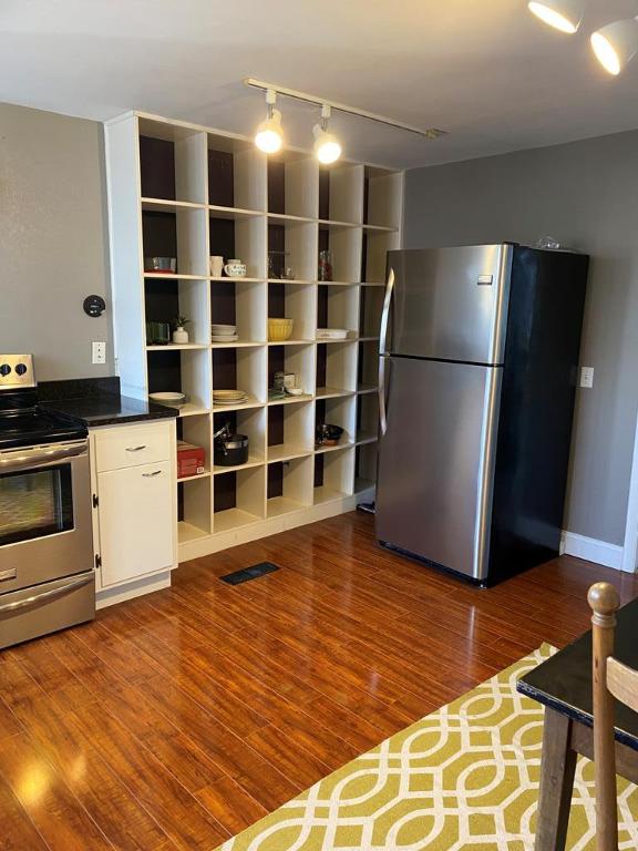 kitchen featuring hardwood / wood-style flooring, rail lighting, appliances with stainless steel finishes, and white cabinets