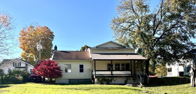 rear view of property with a porch and a yard