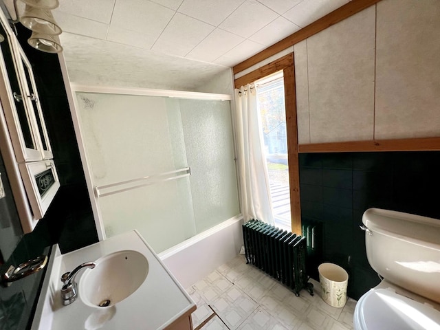 full bathroom with vanity, radiator heating unit, shower / bathtub combination, and toilet