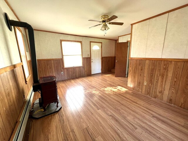 unfurnished living room featuring ceiling fan, ornamental molding, a baseboard radiator, and light wood-type flooring