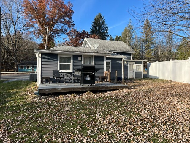 back of property featuring central AC unit, a yard, and a deck