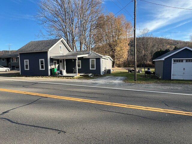 view of front of home featuring a garage, an outbuilding, and covered porch