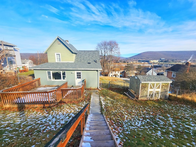 rear view of house with an outdoor structure and a deck with mountain view