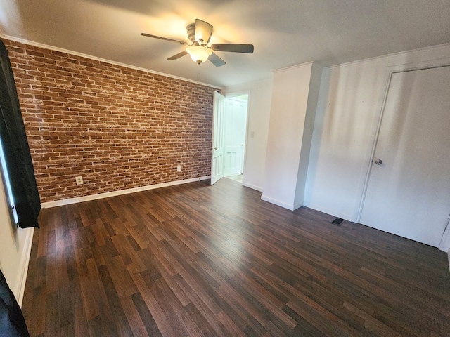 unfurnished bedroom featuring dark hardwood / wood-style flooring, ornamental molding, ceiling fan, and brick wall