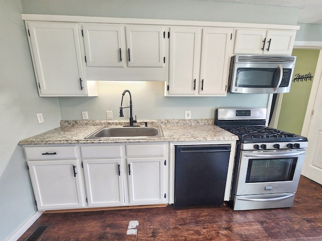 kitchen with appliances with stainless steel finishes, dark hardwood / wood-style floors, sink, and white cabinets