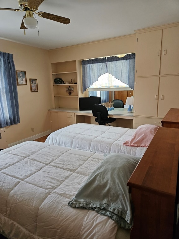 bedroom with built in desk and ceiling fan