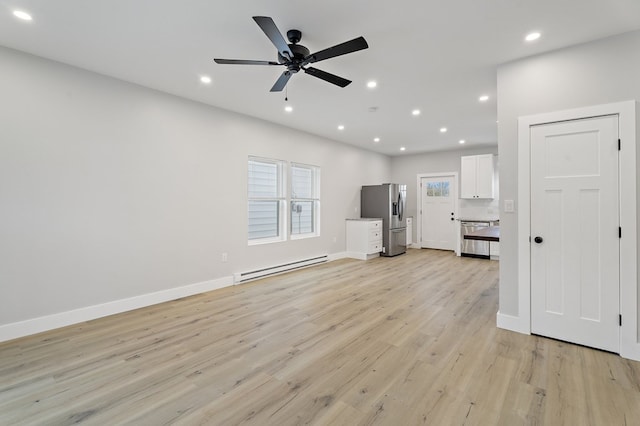 unfurnished living room featuring baseboard heating, ceiling fan, and light hardwood / wood-style floors