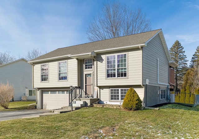 bi-level home with a garage and a front yard