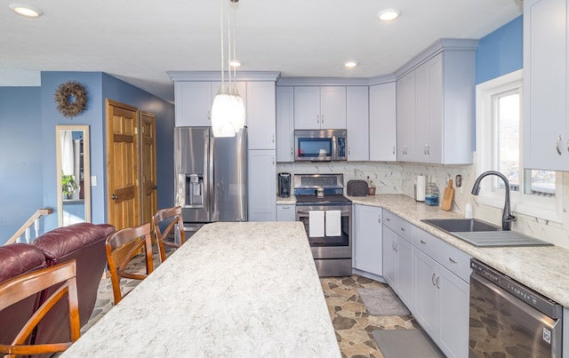 kitchen with stainless steel appliances, decorative light fixtures, sink, and decorative backsplash