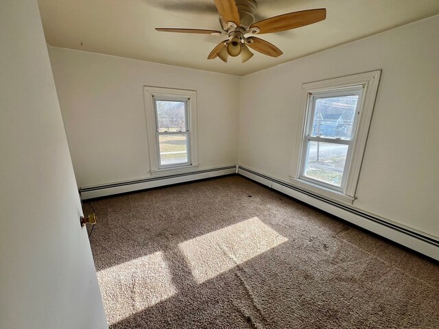 spare room with ceiling fan, carpet, and a baseboard heating unit